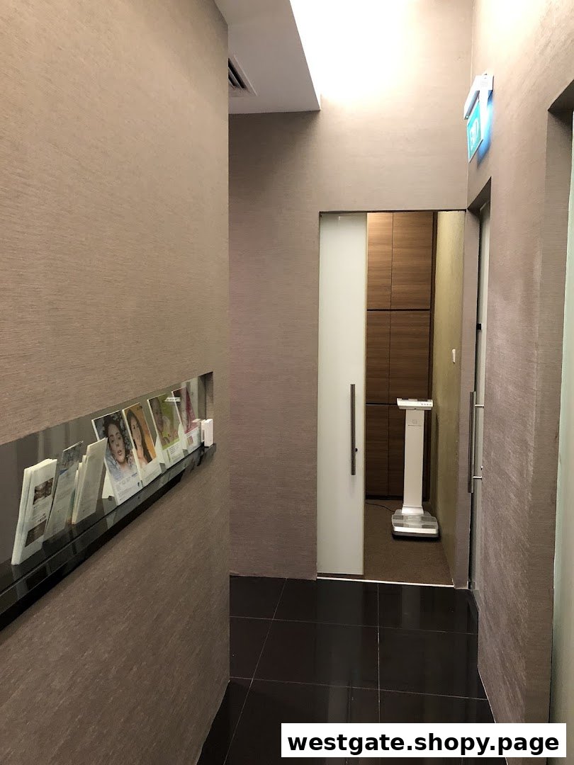 A modern clinic interior hallway with a brochure rack and entrance to a treatment room.