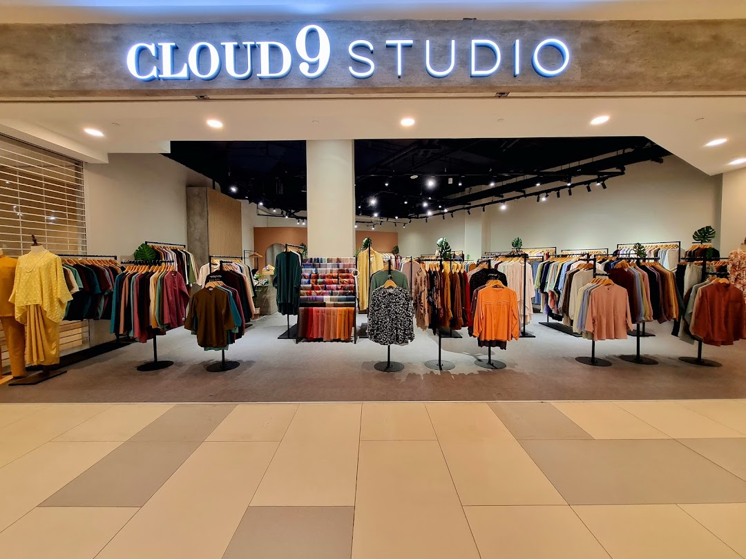 The storefront of Cloud 9 Studio, showcasing a wide array of stylish clothing on display.
