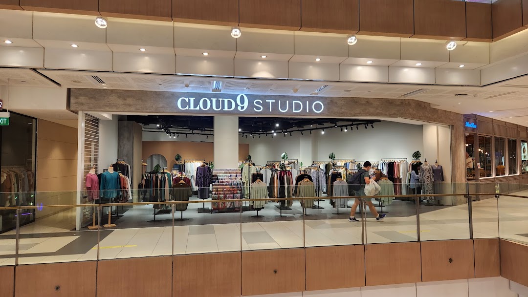 The image shows the brightly lit entrance of Cloud 9 Studio, a clothing store, with racks of apparel visible.
