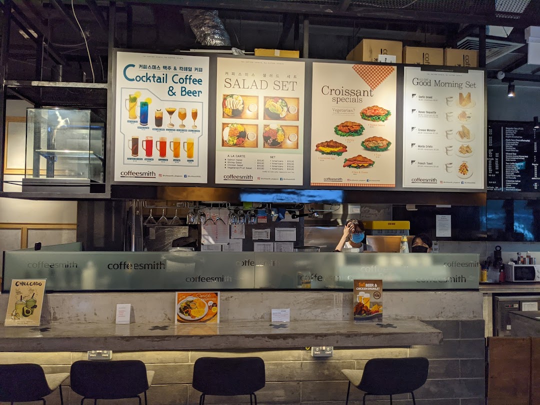 An interior shot of Coffeesmith's counter area, showcasing various menu boards for drinks and food.