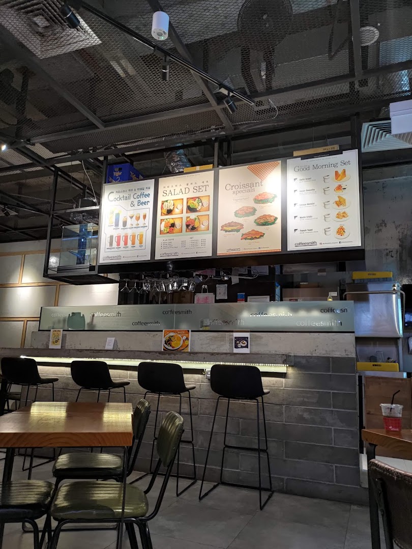 Interior view of Coffeesmith featuring menu boards for coffee, salads, croissants, and breakfast sets.