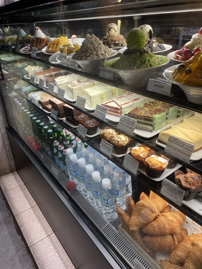A vibrant display case showcasing various cakes, bingsu, pastries, and beverages at Coffeesmith.