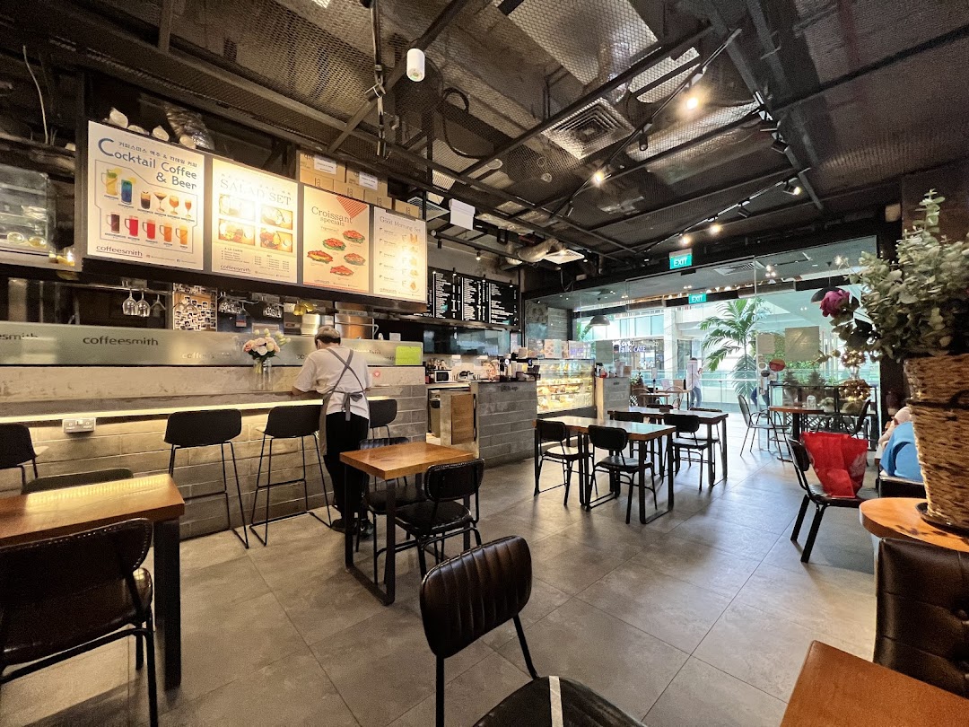 Interior view of Coffeesmith cafe with seating, counter, and a staff member.
