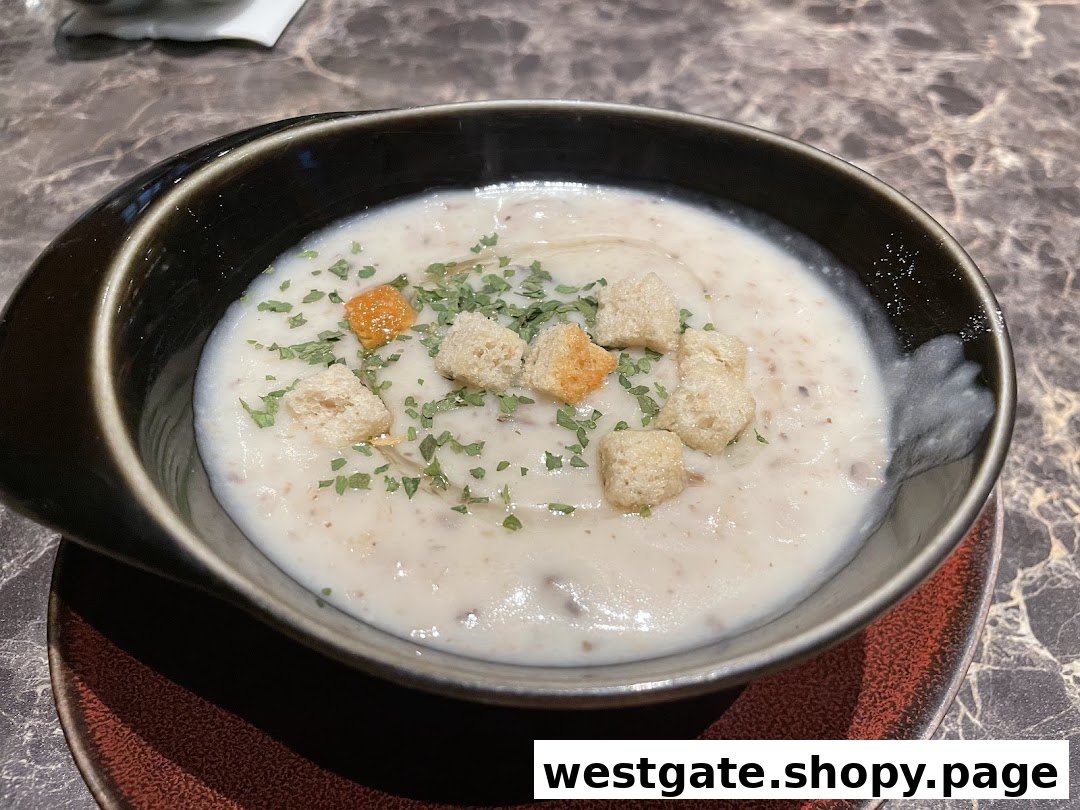 A creamy mushroom soup topped with croutons and fresh herbs in a dark bowl.