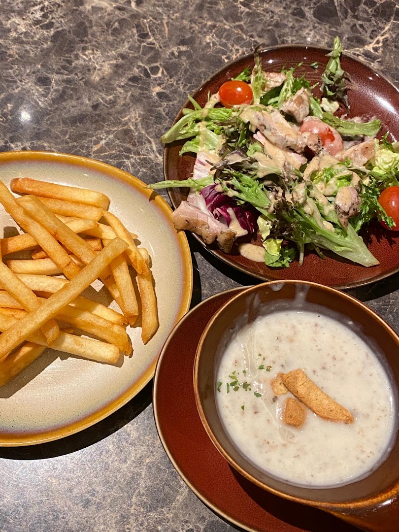 A delicious meal featuring french fries, a fresh salad with chicken, and creamy mushroom soup.