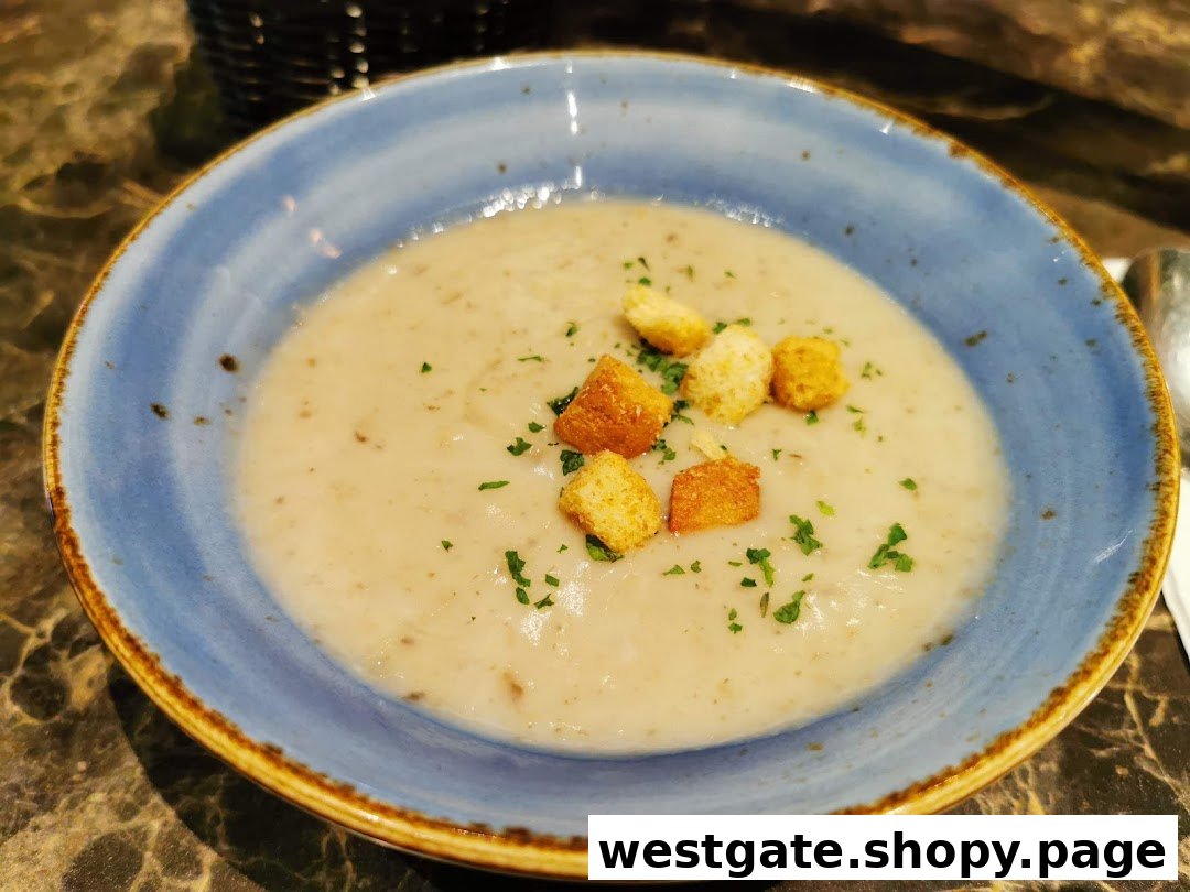 A close-up of a creamy mushroom soup with croutons and parsley in a blue bowl.
