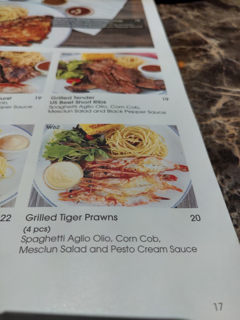 A close-up view of a menu page displaying grilled dishes with their descriptions and prices.