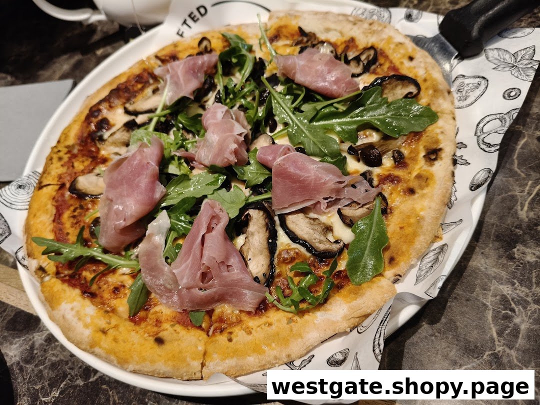 A delicious pizza topped with prosciutto, mushrooms, and arugula on a white plate.