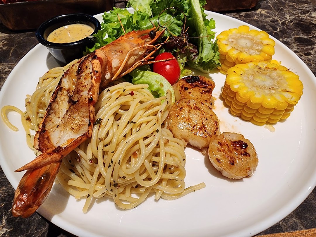 A delicious plate featuring grilled prawn, spaghetti, seared scallops, corn, and salad.