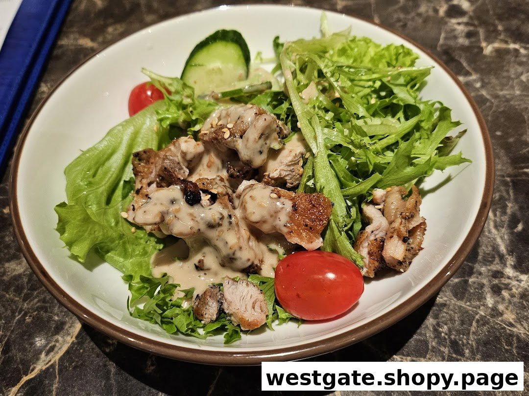 A close-up of a fresh salad with grilled meat, creamy dressing, and vegetables in a white bowl.