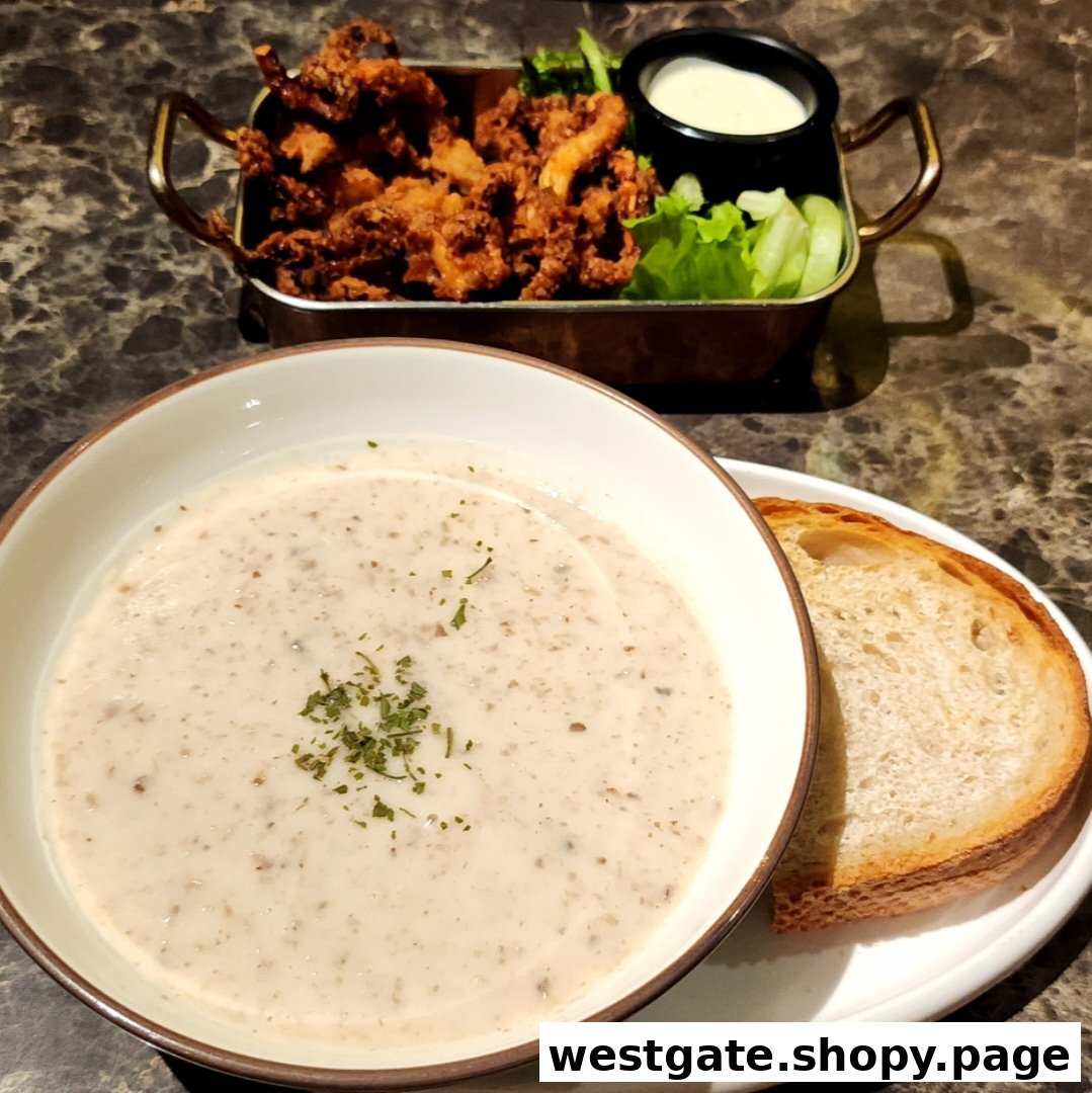A creamy mushroom soup with bread and a tray of crispy fried calamari with dipping sauce.