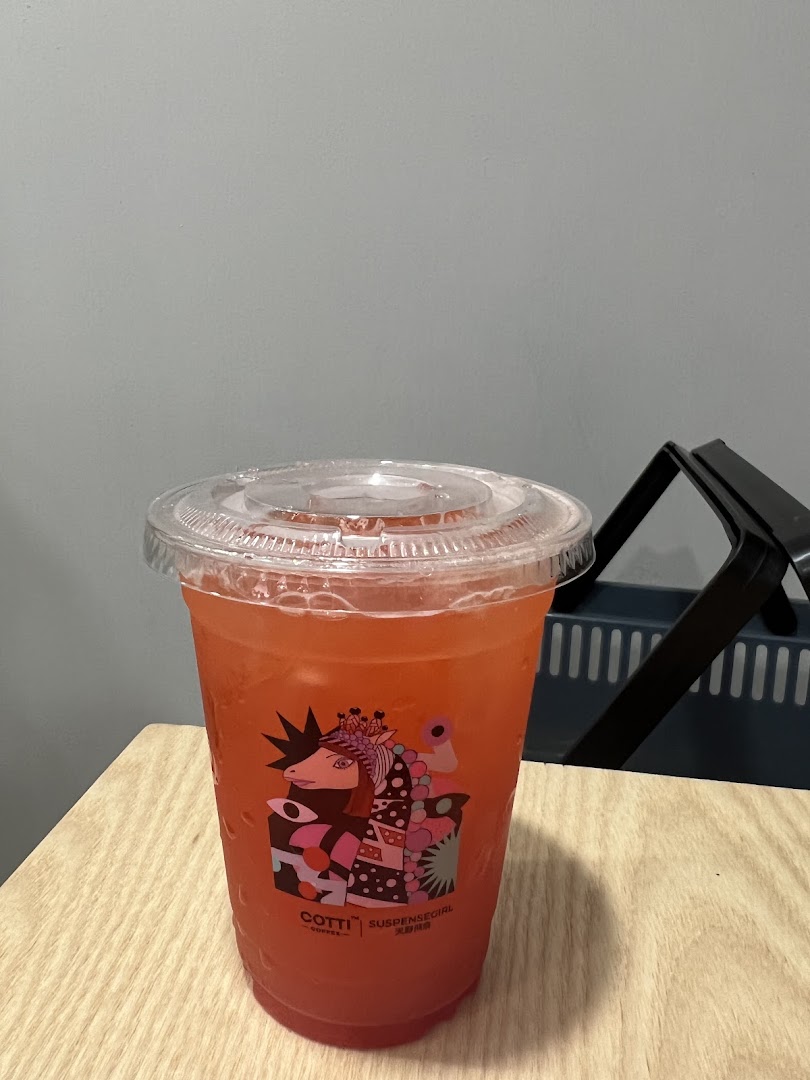 A vibrant red beverage from Cotti Coffee, featuring unique 'Suspensegirl' artwork on the cup.