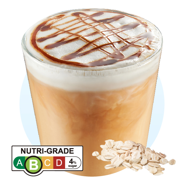 A close-up of a Cotti Coffee drink with foam, caramel drizzle, a Nutri-Grade label, and oats.