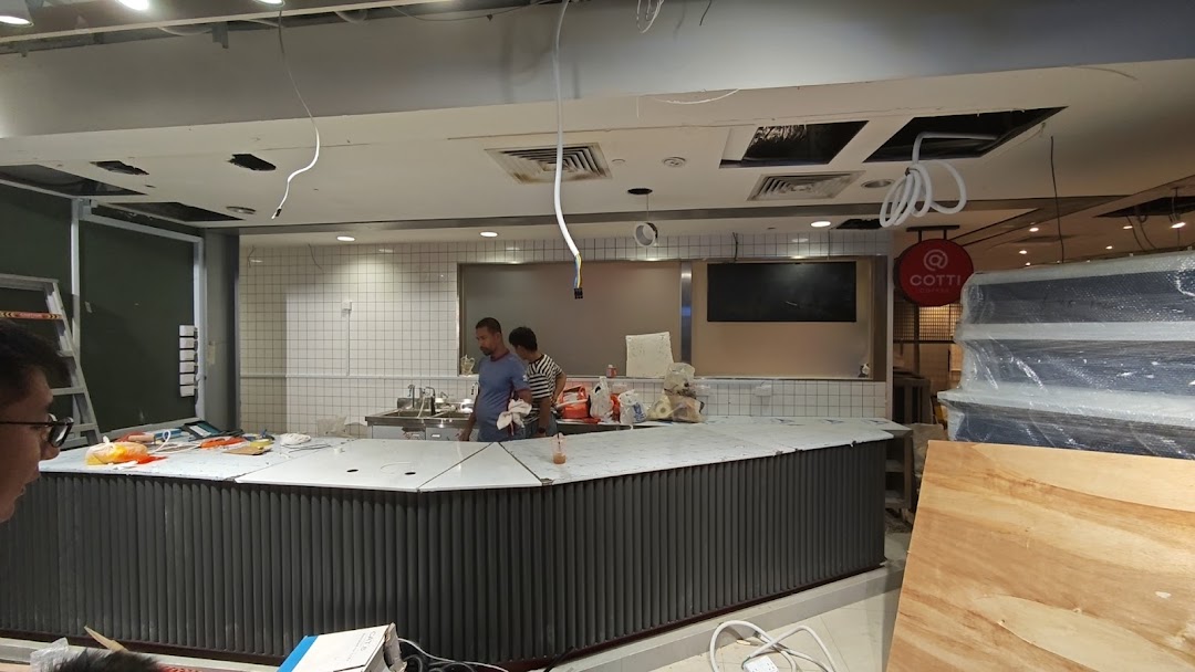 Interior view of Cotti Coffee under construction, featuring the counter area and workers.