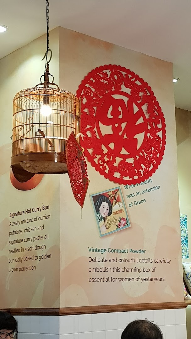 Interior wall decor at Curry Times featuring a birdcage light, red paper cutouts, and descriptive text.