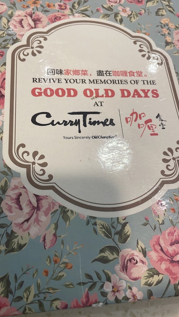 A floral-patterned sign for Curry Times, featuring its logo and 'Revive Your Memories of the Good Old Days' slogan.