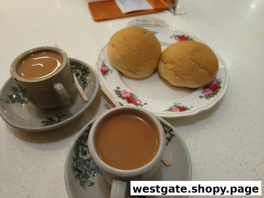 Two cups of traditional milk tea and two golden buns served on a table.