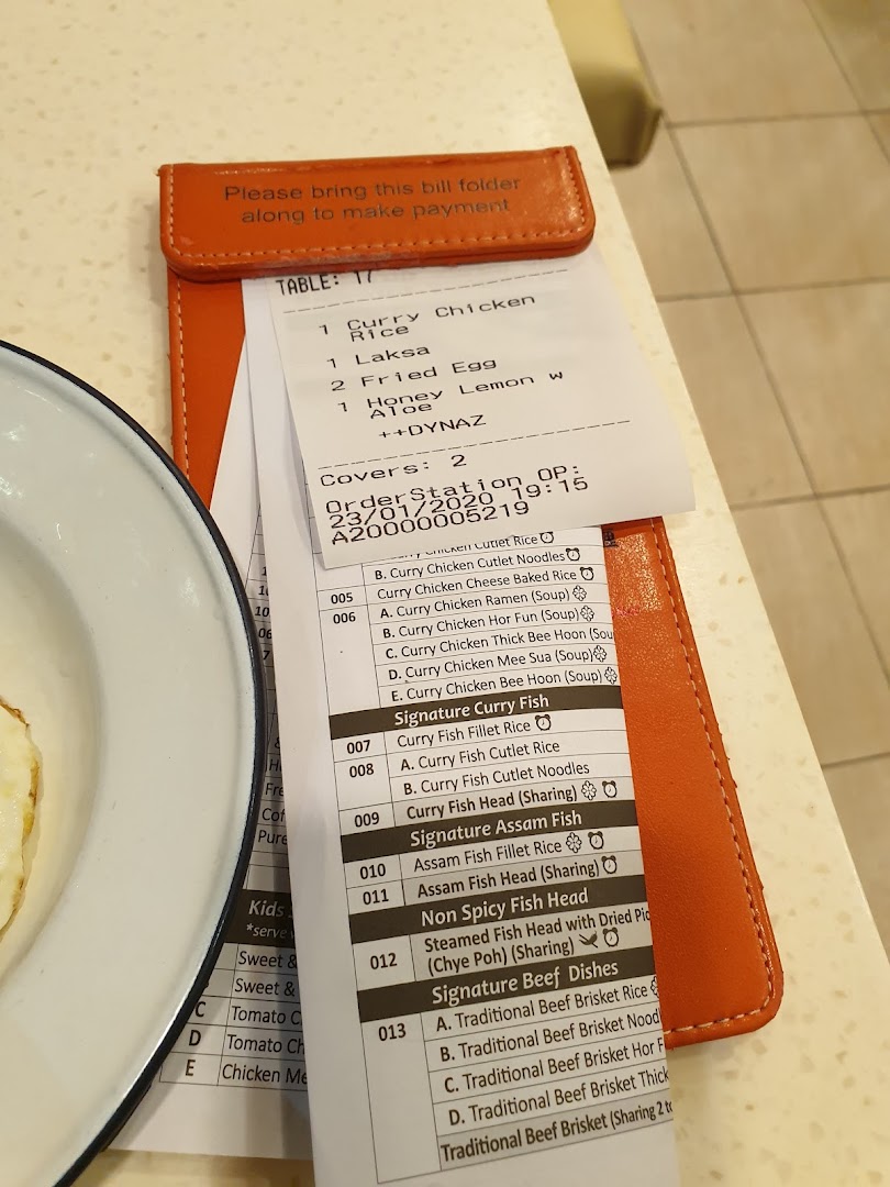 A bill folder with an order slip and a partial menu showing various curry and Asian dishes.