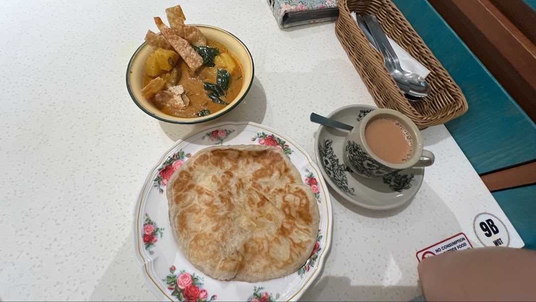 A delicious meal featuring curry, flatbread, and a cup of milk tea on a table at Curry Times.