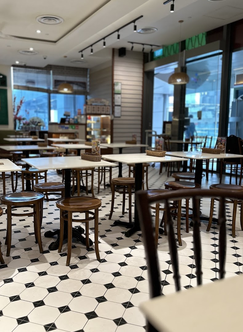 Interior view of Curry Times restaurant with empty tables, stools, and distinctive black and white tiled flooring.