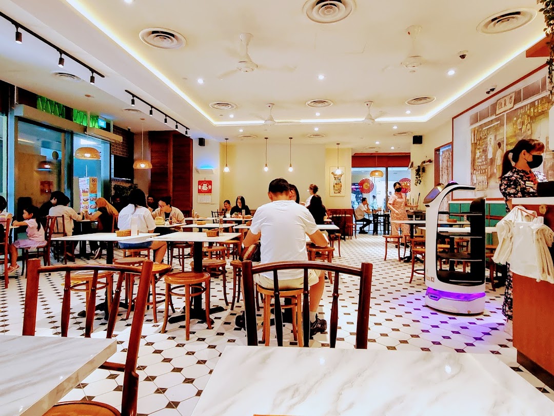 A vibrant interior view of Curry Times restaurant, showing customers dining and a serving robot.