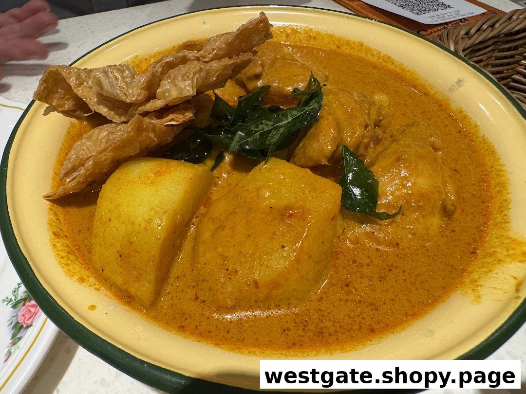 A vibrant yellow curry dish with chicken, potatoes, and bean curd skin in a traditional bowl.