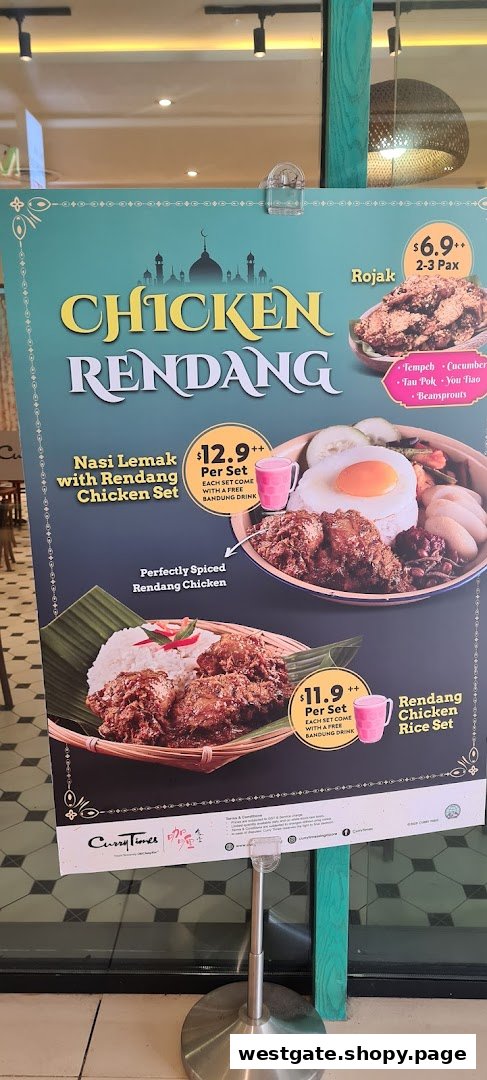 A promotional standee displaying Chicken Rendang dishes and prices from Curry Times.
