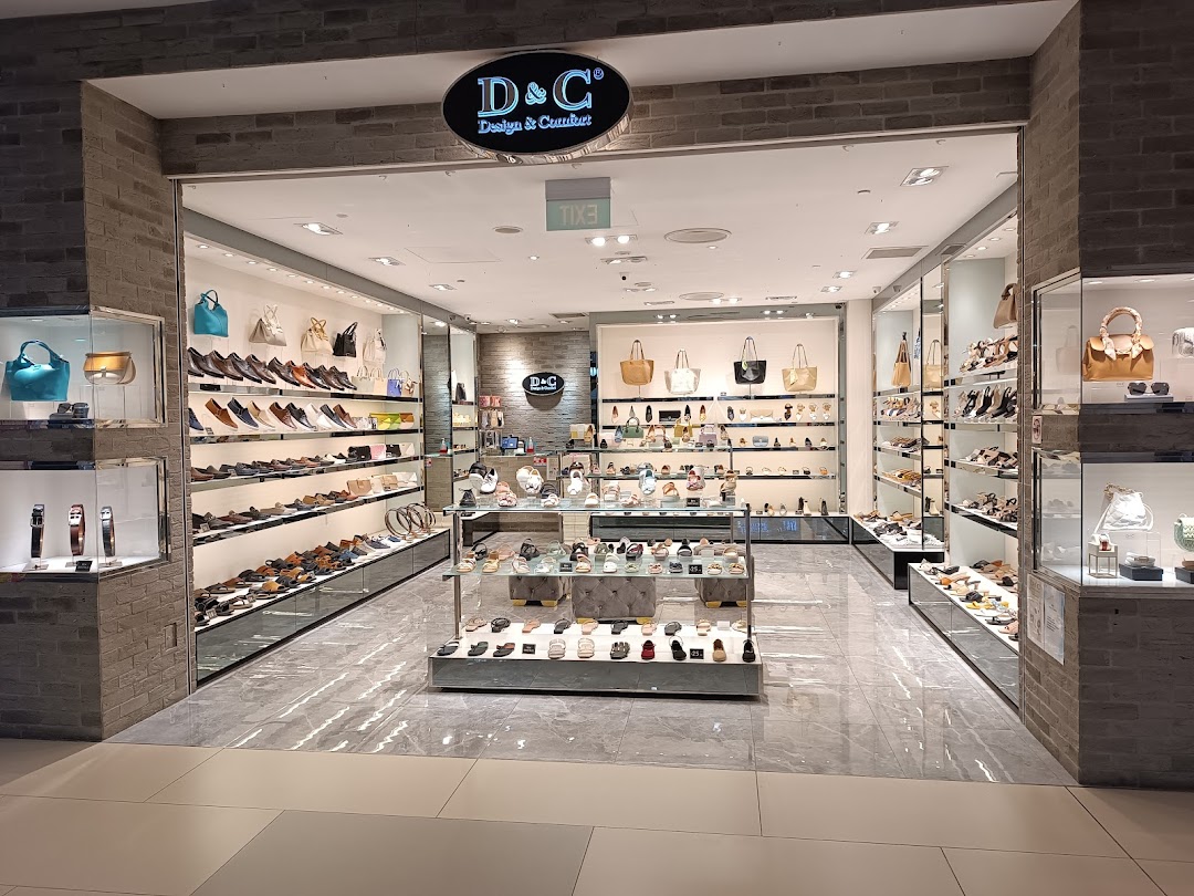 The shopfront of 'DC - Design & Comfort' showcasing a wide array of shoes, bags, and accessories.