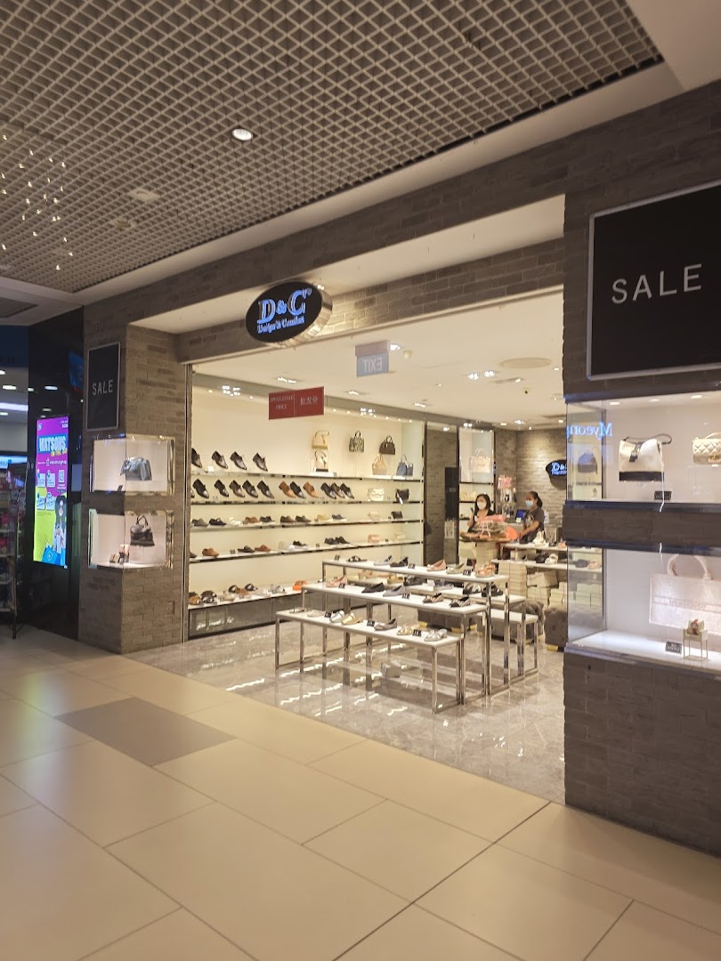 The shop front of 'D&C Design & Comfort' showcasing a wide selection of shoes and handbags.