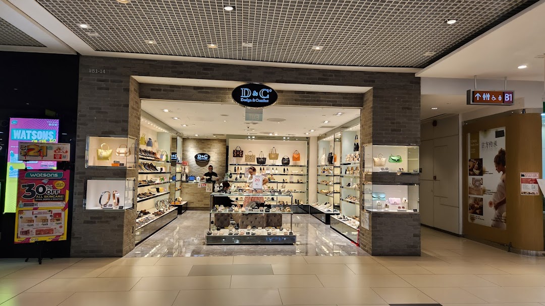 The storefront of DC - Design & Comfort, a retail shop displaying a wide range of shoes and handbags.