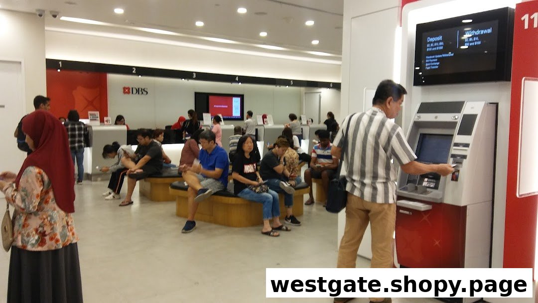 Customers are seen inside a busy DBS bank branch, with some waiting and one using an ATM.