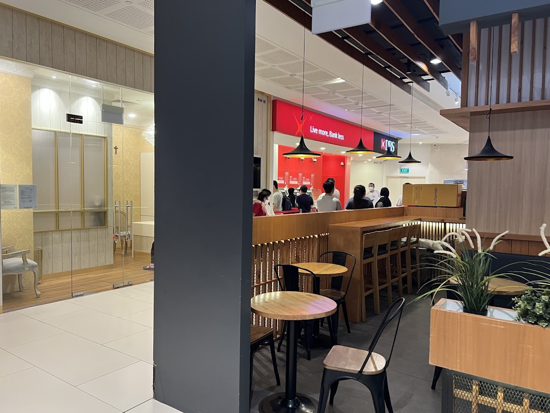 Interior view of a shopping mall featuring the DBS bank branch and adjacent seating area.