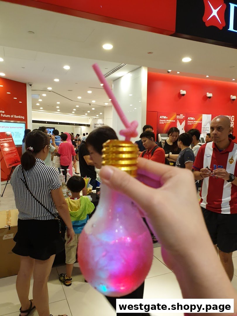 Interior view of DBS Westgate Branch with customers and a person holding a novelty light-up drink.
