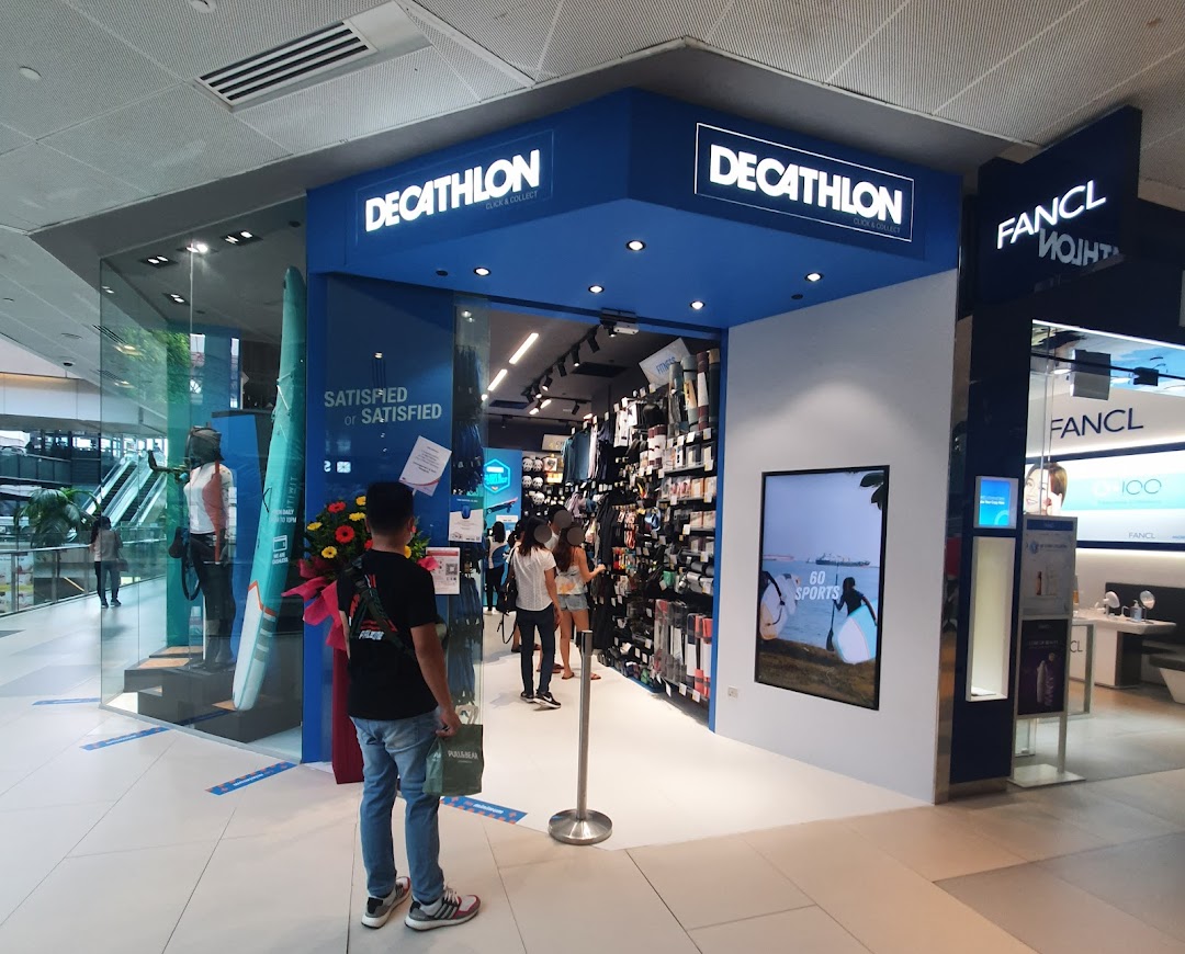 The image shows the blue facade and entrance of Decathlon Westgate Click & Collect store, with sports gear visible inside.