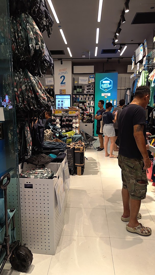 Customers browse sports equipment and apparel inside Decathlon, featuring a 'Click & Collect' station.