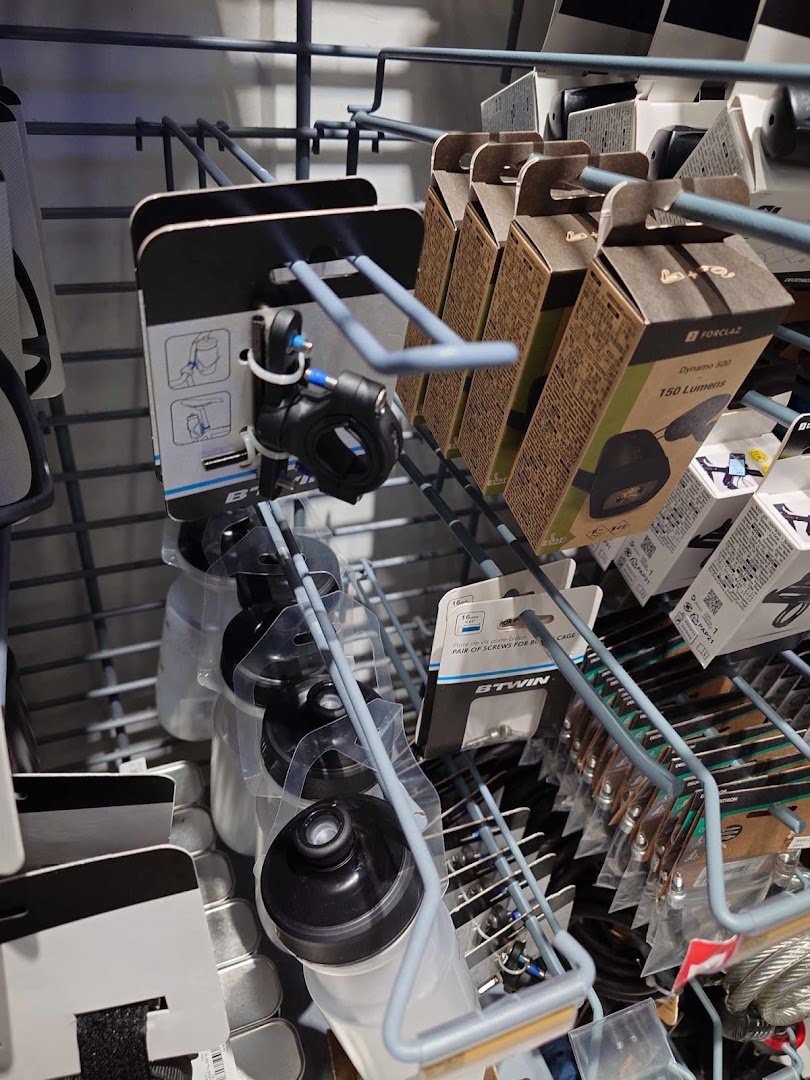A retail display rack showcasing cycling accessories like lights, water bottles, and mounting hardware.