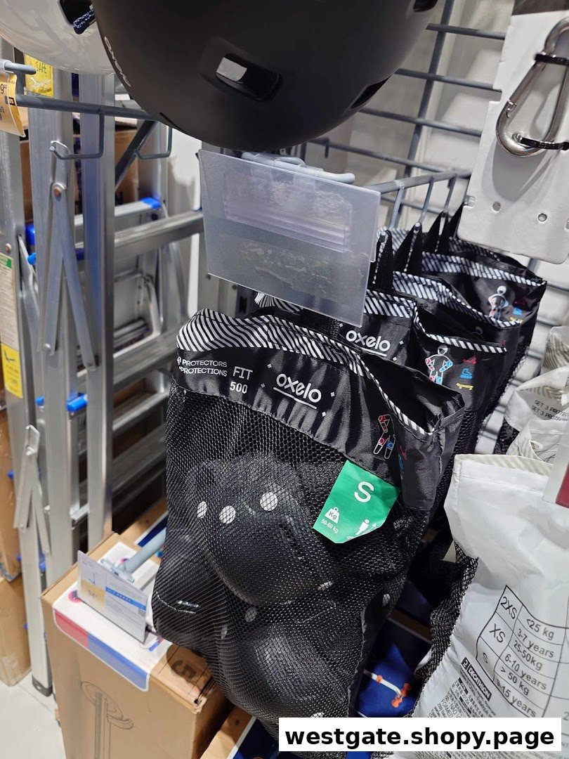 Close-up of Oxelo protective gear and helmets on display at Decathlon, showcasing sports safety equipment.