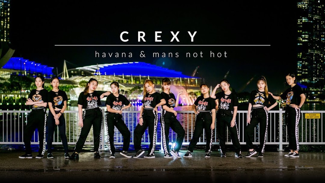 A group of dancers from DF Academy posing at night with a city skyline, promoting a performance.