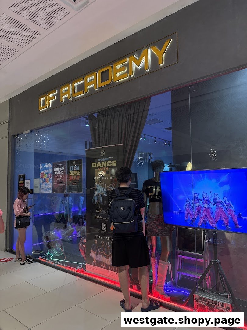 The storefront of DF Academy, a dance studio, with a large glass window displaying promotional materials and a video screen.