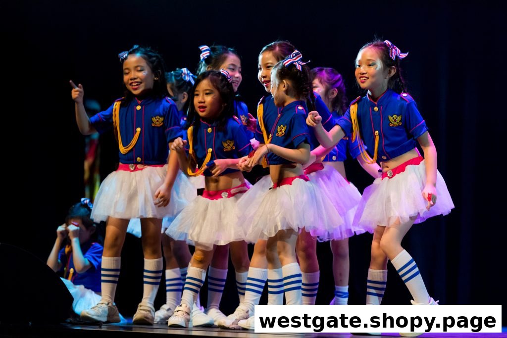 Young girls in vibrant costumes perform on stage, showcasing their talent and joy.