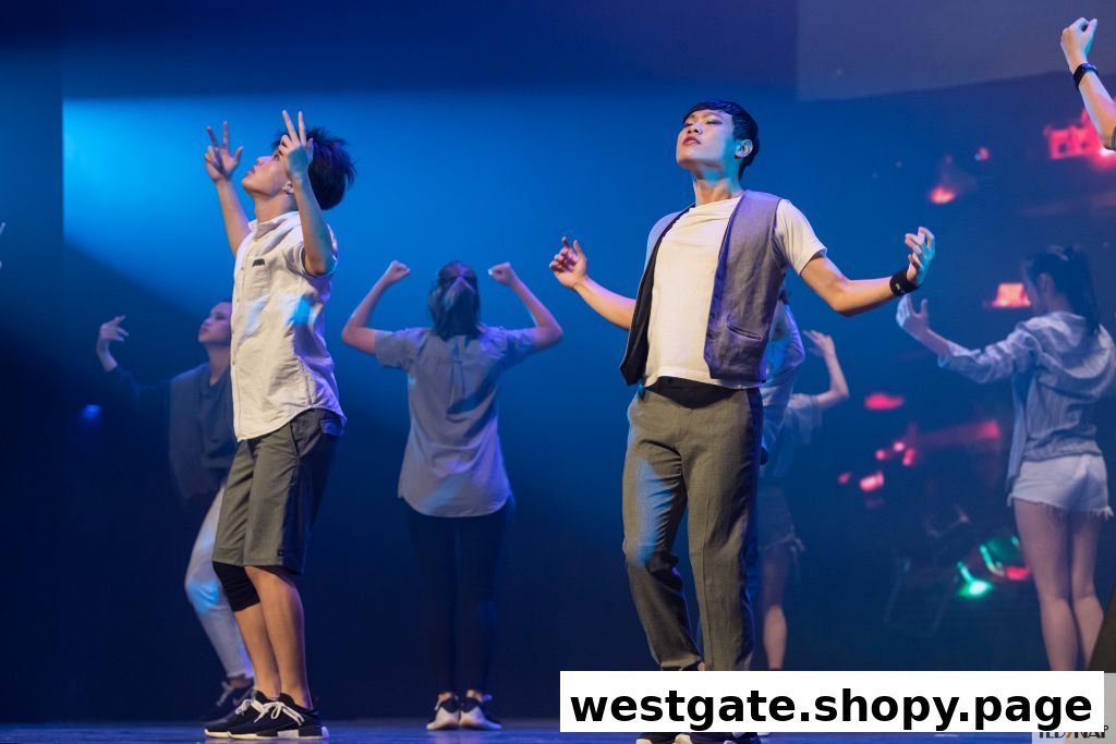 Students perform on stage under blue lighting, showcasing their dance or drama skills.