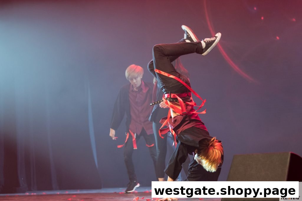 Performers showcase dynamic moves on stage with red ribbons and dramatic lighting.