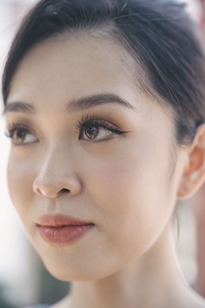 Close-up of a woman's face showcasing beautifully applied lash extensions and subtle makeup.