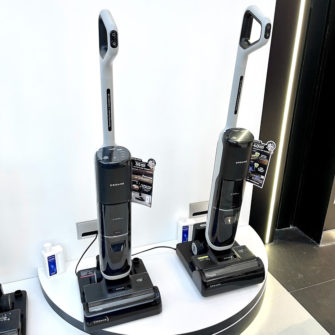 Two Dreame brand wet and dry vacuum cleaners displayed in a retail store.