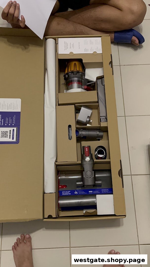 A new Dyson vacuum cleaner is unboxed, revealing its components neatly packed in the box.