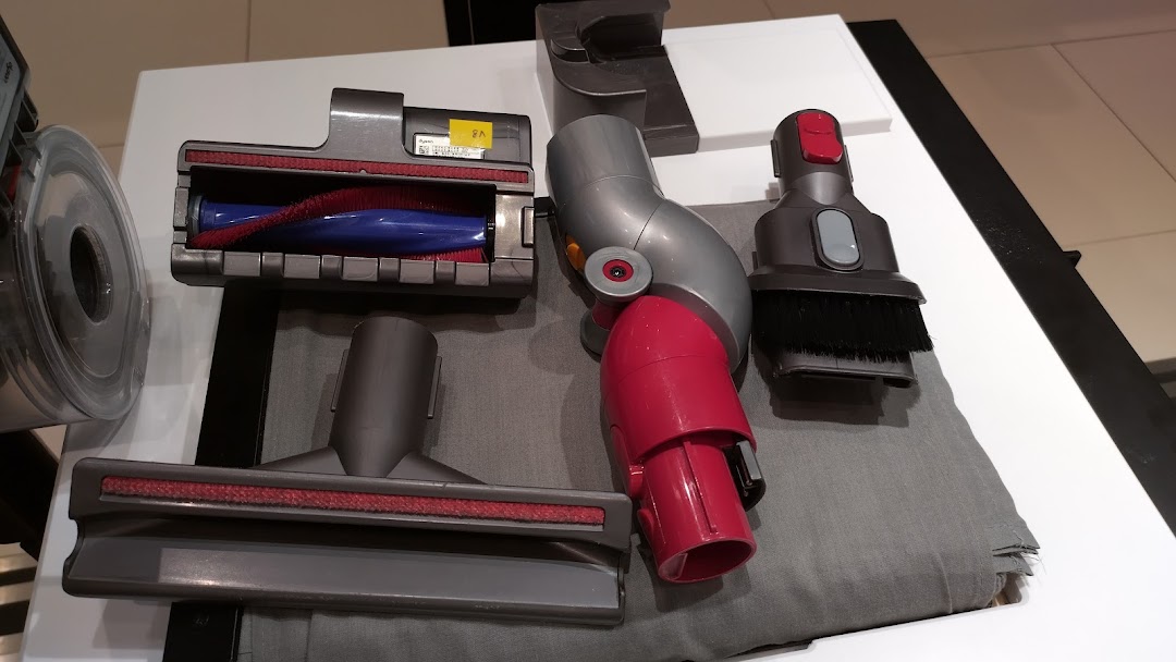 Close-up of various Dyson vacuum cleaner attachments and accessories on display.
