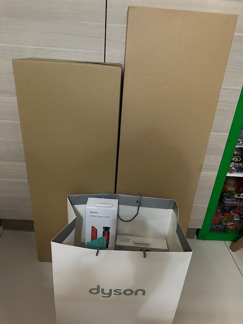 Dyson products, including a detail cleaning kit, in a shopping bag and large boxes.