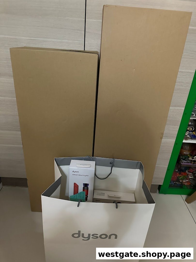 Dyson products, including a detail cleaning kit, in a shopping bag and large boxes.