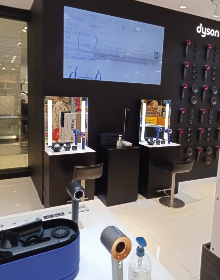 Interior view of Dyson store showcasing hair styling products and interactive demonstration stations.