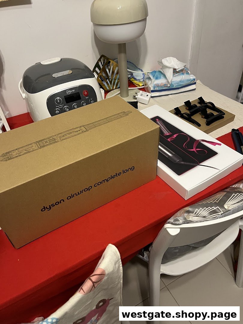 A Dyson Airwrap Complete Long box and another Dyson product box displayed on a red table.